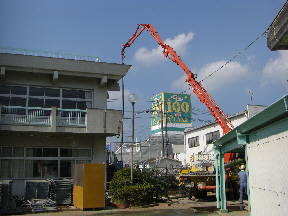 本館校舎脇のミキサー車からコンクリートが送られています\\