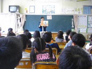 交流読書　先生の紙芝居を集中して聞く２年生の子どもたち(8:15)