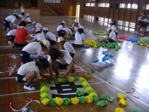 看板で花飾りをつける子どもたち(15:35)