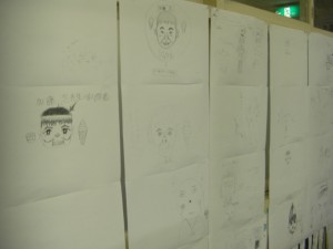 教室に飾られた子どもたちの作品です。先生の大好物なども上手に描かれていますね。(16:35)