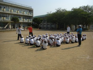 バトンパスの仕方について説明を聞く子どもたち(7:55)