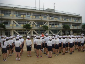 「休み時間や昼休みなど，限られた時間を有効に生かして練習を進めましょう。」体育主任の先生のアドバイスを聞く子どもたち(8:00)