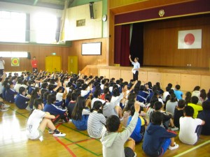 校長先生の問いかけに挙手をする子どもたち(8:10)