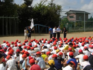 避難した児童数を確認し，校長先生に報告する本校職員(9:42)