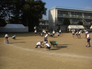 グラウンドのライン引き　石拾いを行う子どもたち(15:25)