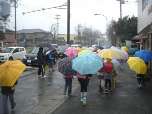 雨の中，足早に学校へと向かう子どもたち(7:45)