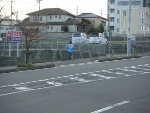 駆け足で学区内を移動しながら，子どもたちの登校安全を確認する髙﨑先生(7:50)