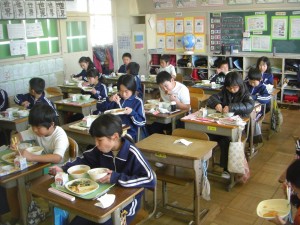 食事をする子どもたち　風邪が流行しているため，予防のため全員前を向いて食事をしています。(12:30)