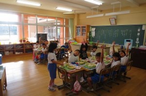 IMG_2560 1年生の教室です。子ども達が手を挙げている理由は,「カレー好きな人?」の問いに,「ハーイ」と答えているところです。\