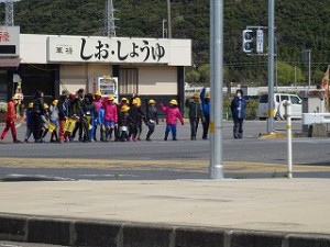 DSC01088 この写真は,道路の歩き方や横断歩道の渡り方を実際に体験して学ぶ豊津小学校の交通安全教室です。信号のある横断歩道を渡っています。\