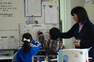 DSC03884 カワイイ1年生の「係活動」引継の風景です。2学期の女の子から3学期は男の子になります。担任も付き添って,仕事の確認をしています。\